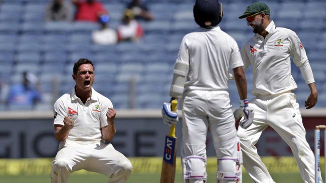 Australia's Steve O'Keefe, left, celebrates the dismissal of India's Ajinkya Rahane on the second day of the first cricket test match in Pune, India.