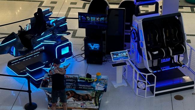 Customers playing on the VR and 3D machines inside a Logan shopping mall.