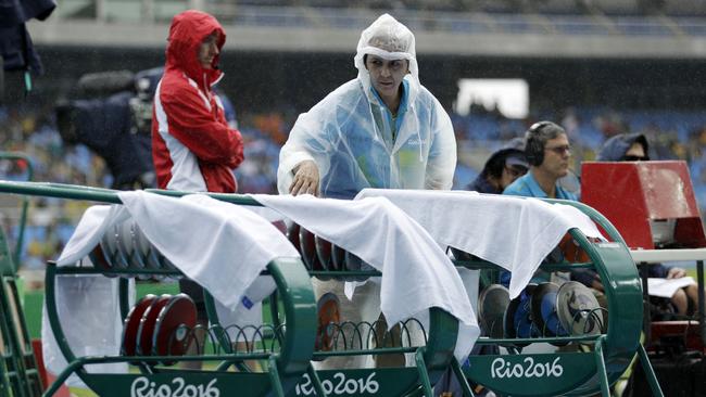 Discus are covered as rain falls. Photo: AP Photo/Matt Dunham