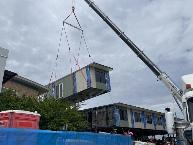 A crane drops in the final building module into the new ward, set for full operations by 2025.