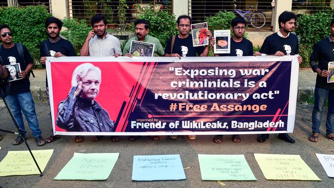 Activists stand behind a banner and hold placards while forming a human chain calling for the freedom of Julian Assange, in Dhaka. Picture: AFP