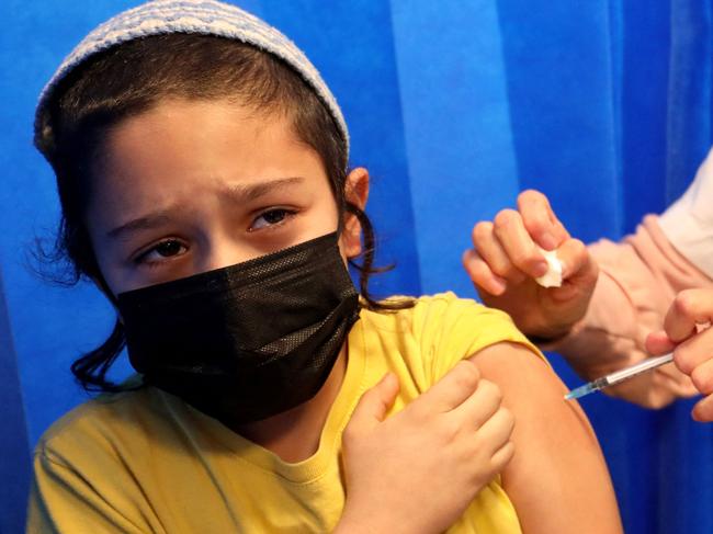 An Israeli health worker administers a dose of the Pfizer-BioNTech COVID-19 vaccine to a child at the Clalit Health Services in the central Israeli city of Modiin on January 2, 2022. (Photo by GIL COHEN-MAGEN / AFP)