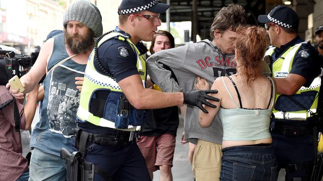 A female rough sleeper tries to stop police arresting a man. Picture: Nicole Garmston