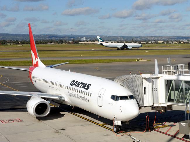 All Qantas flights cancelled for the day at noon. Cathay Pacific flies out in background.