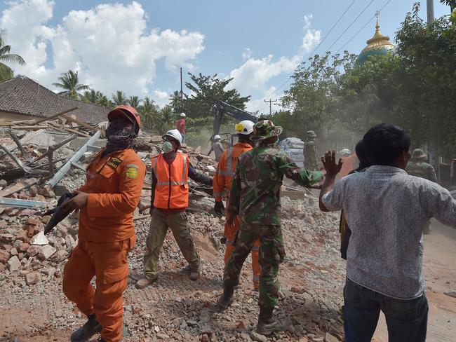 Indonesian search and rescue members react shortly after an aftershock hit Lombok’s Tanjung distric. Picture: AFP