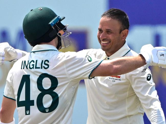 Australia's Usman Khawaja (R) celebrates with his teammate Josh Inglis after scoring a double century (200 runs) during the second day of the first Test cricket match between Sri Lanka and Australia at the Galle International Cricket Stadium in Galle on January 30, 2025. (Photo by Ishara S. KODIKARA / AFP)