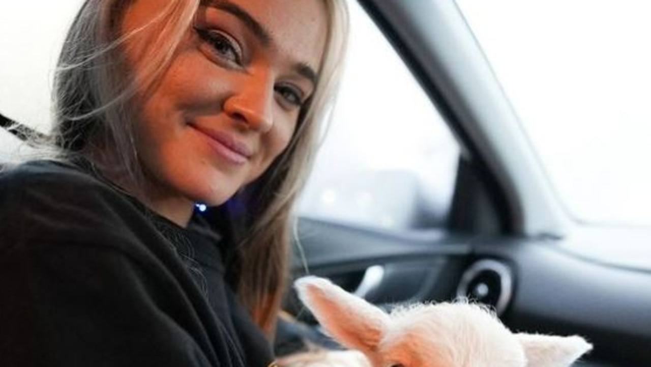 Vegan animal activist – Tash Peterson with a newborn lamb she found in a paddock. Picture: Instagram