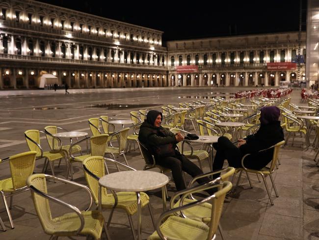 Two foreign tourists talks to each other in a completely empty San Marco Square in Venice, Italy. Picture: Getty Images