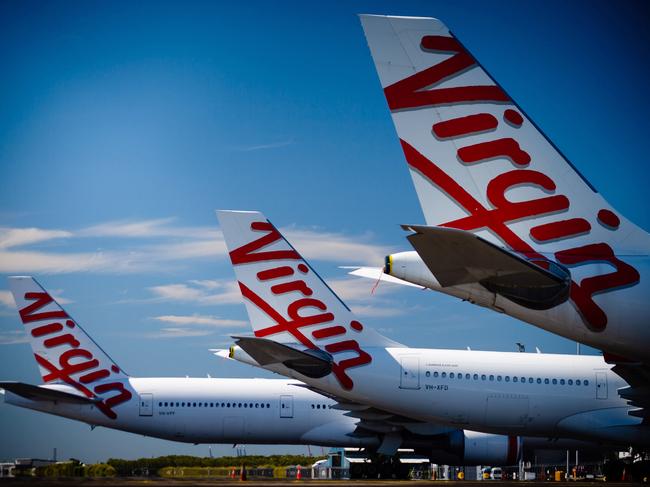 Virgin Australia aircraft are seen parked on the tarmac at Brisbane International airport on April 21, 2020. - Cash-strapped Virgin Australia collapsed on April 21, making it the largest carrier yet to buckle under the strain of the coronavirus pandemic, which has ravaged the global airline industry. (Photo by Patrick HAMILTON / AFP)