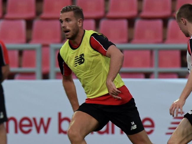 Liverpool football player Jordan Henderson (L) controls the ball during a team training session at Rajamangala stadium in Bangkok on July 13, 2015. Liverpool football team will play an exhibition match with Thai Premier League All-Stars team at Rajamangala stadium in Bangkok on July 14. AFP PHOTO / PORNCHAI KITTIWONGSAKUL