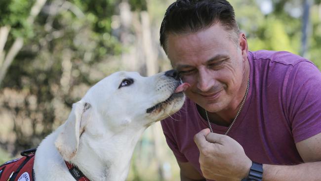 Ex Australian Army infantryman, Andrew Glebow gets a "kiss" from his new "Assistance Dog" Leon in his back yard in Shailer Park, Brisbane.