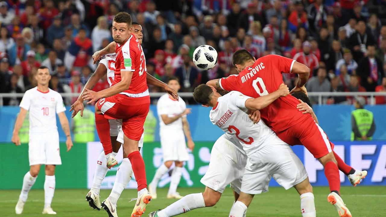 Serbia's forward Aleksandar Mitrovic is brought down by two Switzerland defenders.