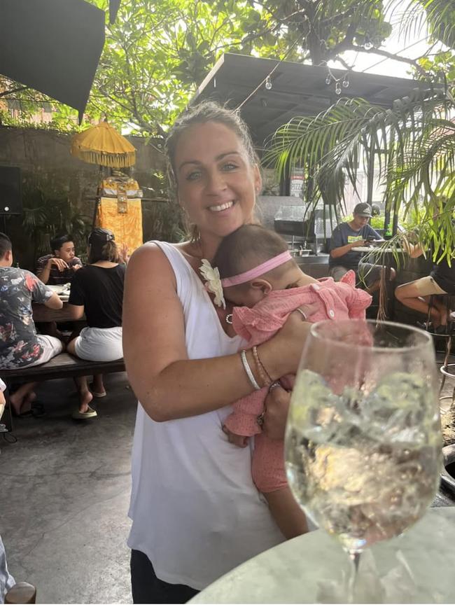 Lynley Le Grand, who was found guilty of running a brothel in Bali, is pictured with a customers baby at her restaurant the Corner House in Bali.