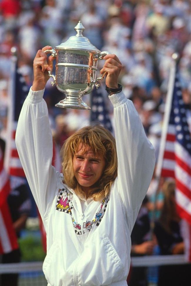 3 (tie). Steffi Graf (Germany) — 22 major titlesGraf's model was consistency, holding her place at number one for a record 377 weeks—the longest of any player. She could win on all surfaces, and in 1988 became the first player to achieve a calendar Golden Slam, winning all four majors and Olympic Gold in the same year.