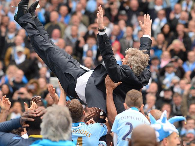 Manchester City manager Manuel Pellegrini is thrown in the air by his players.