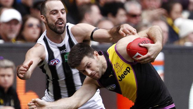 Steele Sidebottom of the Magpies tackles Trent Cotchin of the Tigers during the Round 19 AFL match between the Richmond Tigers and the Collingwood Magpies at the MCG in Melbourne, Saturday, July 28, 2018. (AAP Image/Daniel Pockett) NO ARCHIVING, EDITORIAL USE ONLY