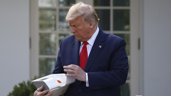 US President Donald Trump opens a box containing a quick test for COVID-19. Picture: Alex Brandon/AP