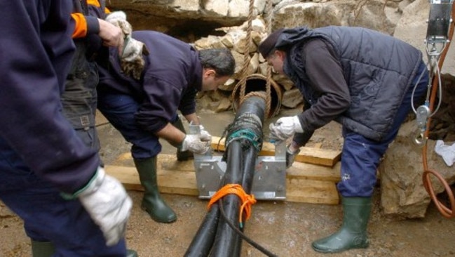 Italian technicians manipulate a high-tension under-sea cable 14 December 2005 in the port of Santa Teresa di Gallura, Italian island of Sardinia, linking it with Bonifacio, French island of Corsica, as part of an electricity exchange project. AFP PHOTO STEPHAN AGOSTINI