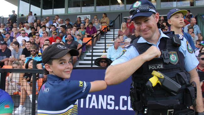 An NRL ball boy gives an officer some pointers on the game. Photo: Alison Paterson