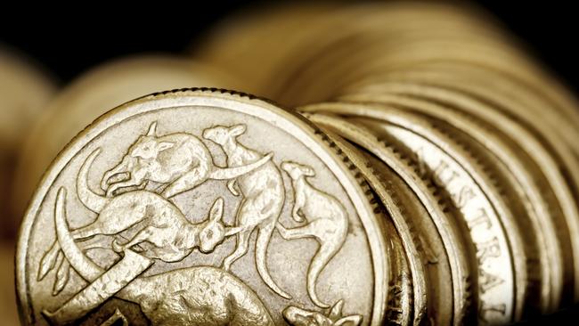 Australian one dollar coins over black background.