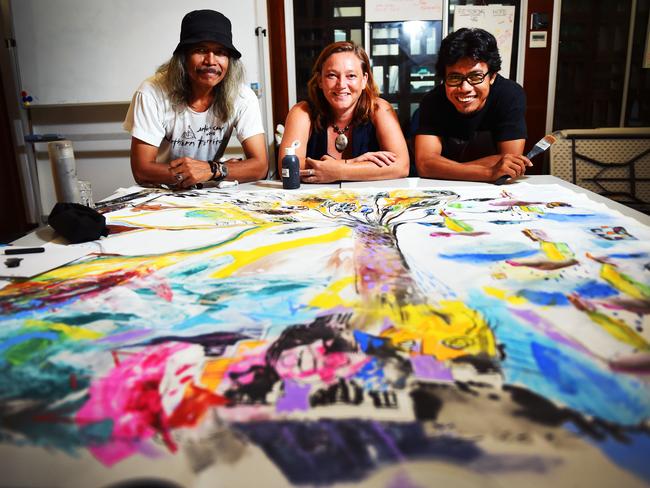 Bali Artists, Made Budhiana, Iwayan Wiirawon and the CEO of Melaluca Refugee Centre, Caz Coleman, stand by an artwork which took six weeks to complete and will be handed over to the refugee centre, as a sign of "humanity".