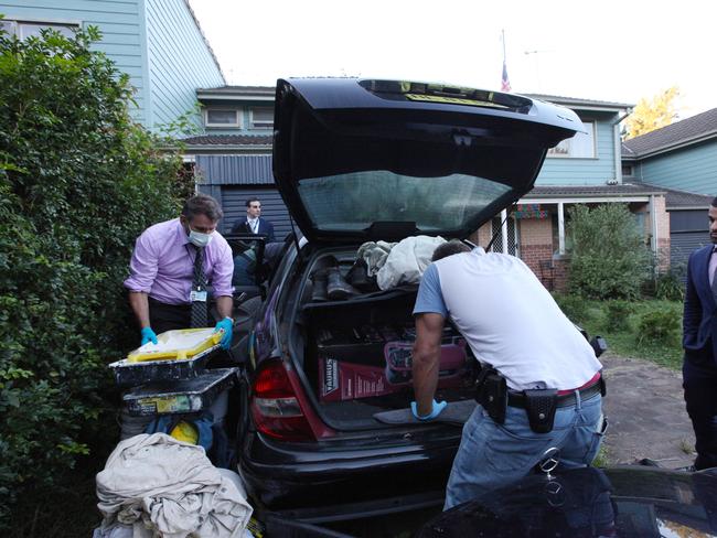 Australian Federal Police officers search Khaja’s car for evidence.