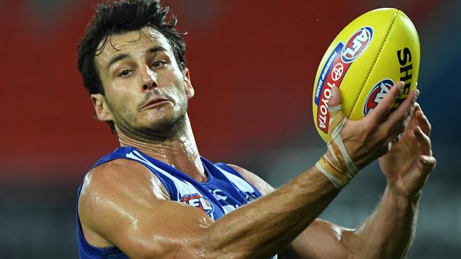 GOLD COAST, AUSTRALIA - SEPTEMBER 05: Robbie Tarrant of the Kangaroos handballs during the round 16 AFL match between the North Melbourne Kangaroos and the Port Adelaide Power at Metricon Stadium on September 05, 2020 in Gold Coast, Australia. (Photo by Matt Roberts/AFL Photos/via Getty Images)