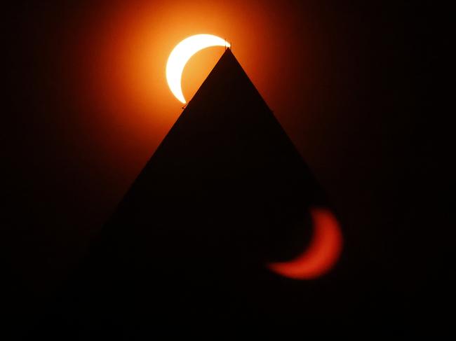 The solar eclipse is seen and reflected above the Washington Monument. Picture: Chip Somodevilla/Getty Images