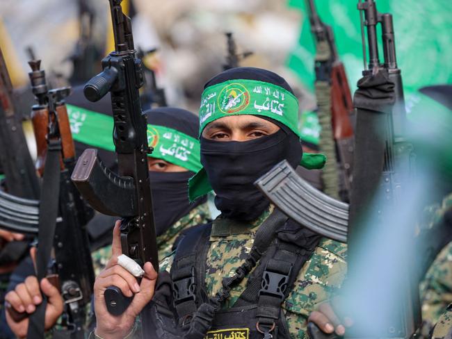 Hamas fighters secure an area in a square before handing over four Israeli hostages to a Red Cross team in Gaza City on January 25, 2025. Four freed Israeli women hostages were home in Israel January 25, ending more than 15 months of captivity after Hamas militants handed them over to the Red Cross under a truce deal in the Gaza war. (Photo by Omar AL-QATTAA / AFP)