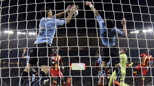 Uruguay's Luis Suarez, left, stops the ball with his hands during the 2010 World Cup quarter-final