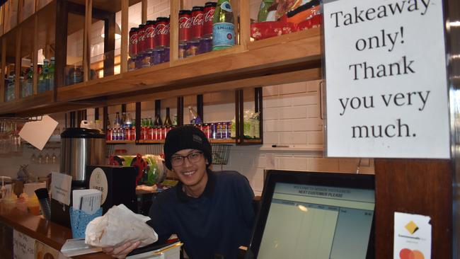 Mission Vietnamese waiter Lincoln Dang serves some takeaway at Coorparoo Square. Picture: Brian Bennion