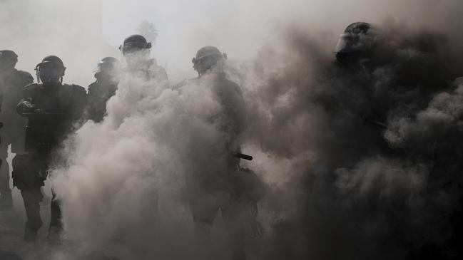 Police are seen through smoke on the 101 Freeway. Picture: AP