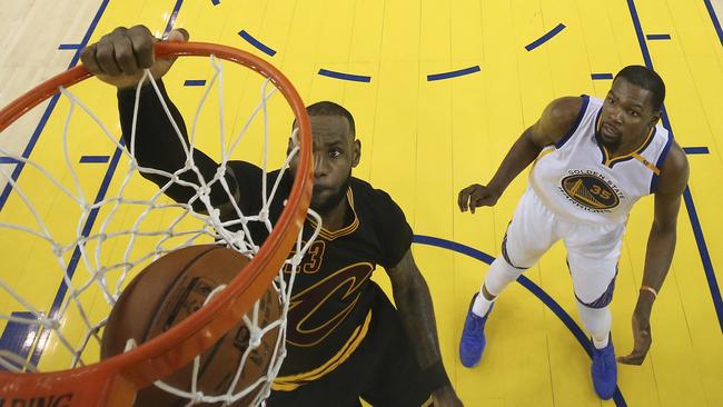 Cleveland Cavaliers forward LeBron James, left, dunks in front of Golden State Warriors forward Kevin Durant (35) during the second half of Game 5 of basketball's NBA Finals in Oakland, Calif., Monday, June 12, 2017. The Warriors won 129-120 to win the NBA championship. (Ezra Shaw/Pool Photo via AP)