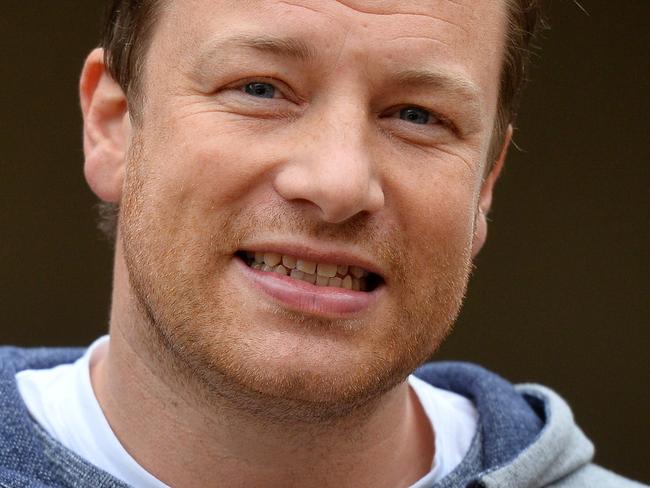 (FILES) This file photo taken on May 20, 2013 shows British chef Jamie Oliver posing for photographers during the Chelsea Flower Show press day in London. Jamie Oliver has caused a storm after posting a picture of his version of the classic Spanish dish paella made with chorizo sausage. / AFP PHOTO / BEN STANSALL