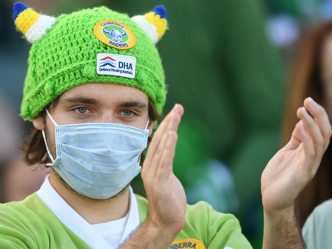 A Raiders fan wears a mask as he applauds a try during the Round One NRL match between Canberra Raiders and Gold Coast Titans at GIO Stadium in Canberra, Friday, March 13, 2020. (AAP Image/Lukas Coch) NO ARCHIVING, EDITORIAL USE ONLY