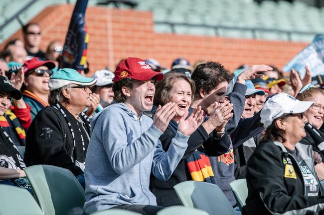 Crows and Port Adelaide fans cheering and sitting together on the southern side of Adelaide Oval as extras in the film 