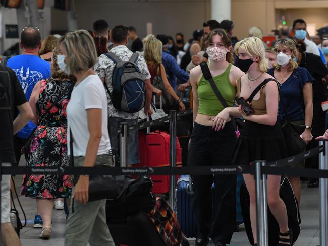 SYDNEY, AUSTRALIA - DECEMBER 18: Airline passengers wait in line to check in at Sydney's Kingsford Smith domestic airport on December 18, 2020 in Sydney, Australia. A cluster of Covid-19 cases on the northern beaches of Sydney has grown to 28, prompting NSW health officials to urge residents of affected suburbs to stay home. Traffic at Sydney Airport has increased as people rush to leave the city with several states imposing quarantine restrictions for New South Wales residents. (Photo by James D. Morgan/Getty Images)