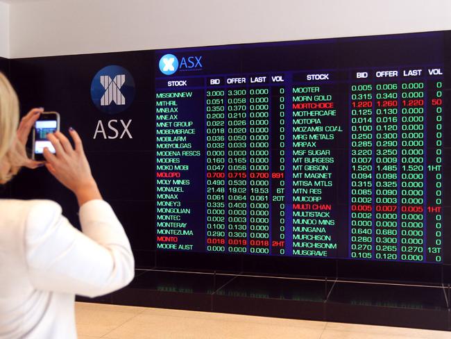 Woman takes a photograph with her mobile phone of the frozen Australian Stock Exchange (ASX) after the organisation suffered a technical glitch forcing the organisation to suspend trading for four hours, pictured in the Sydney CBD.