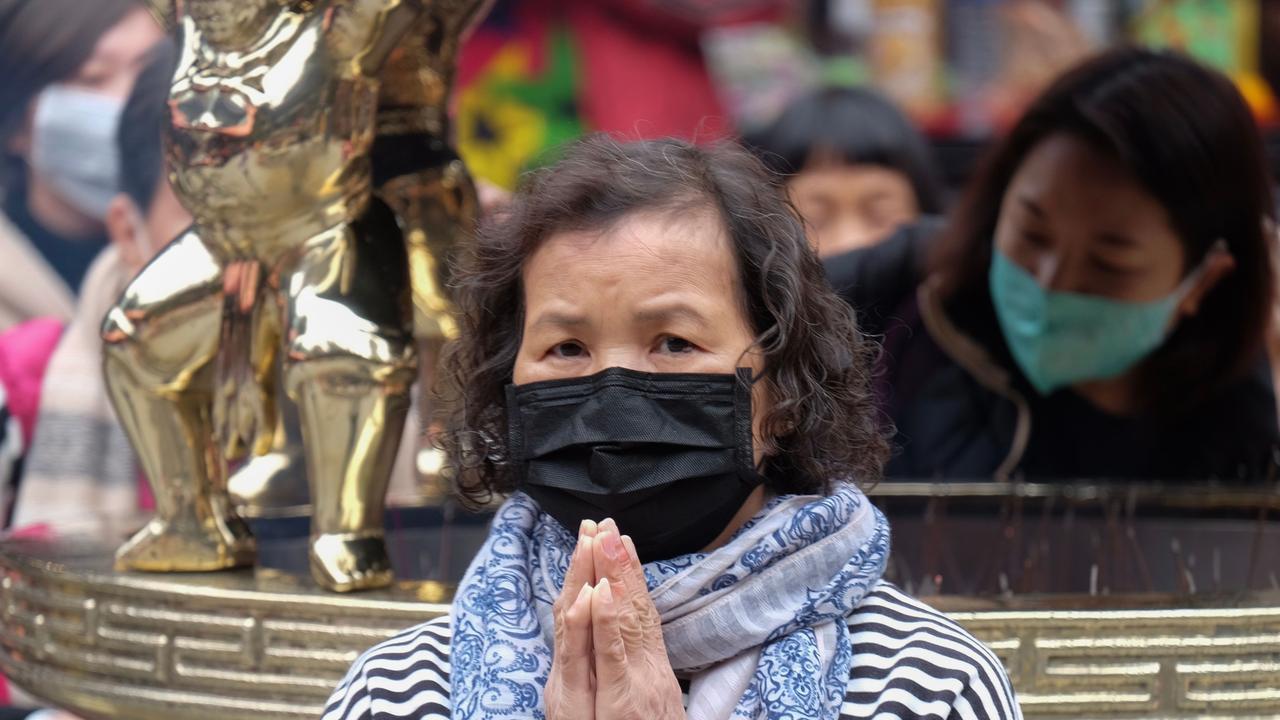 A woman wearing a protective mask prays at the Lungshan temple during the fourth day of the Lunar New year of the Rat in Taipei. Picture: AFP