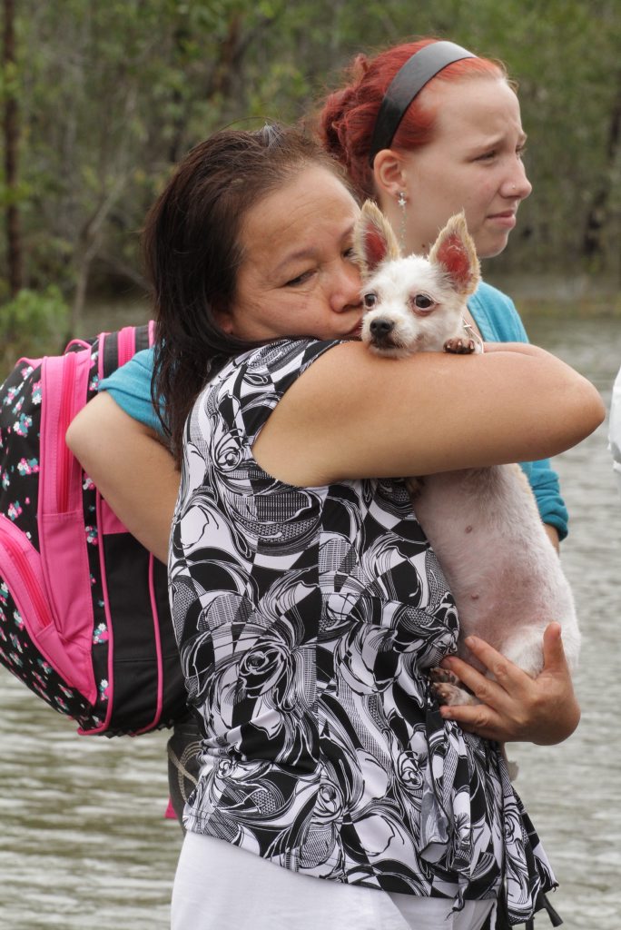 Tinh Lawton with her dog Kitty was emotional after being ferried across the Bruce Highway in a boat after her home in Aldershot was flooded. Photo: Robyne Cuerel / Fraser Coast Chronicle. Picture: Robyne Cuerel