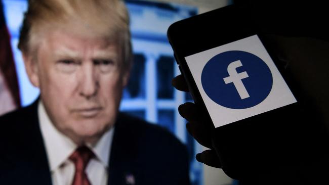 A phone screen displays a Facebook logo near the official portrait of former US president Donald Trump. Picture: AFP