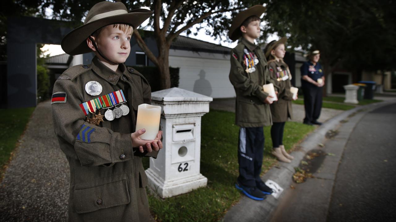 William 7, held a vigil with grandfather David Doughty 66, and cousins Riley, 10, and Kaitlyn, 9, outside their grandfather’s house on Anzac Day in 2020. Picture: David Caird