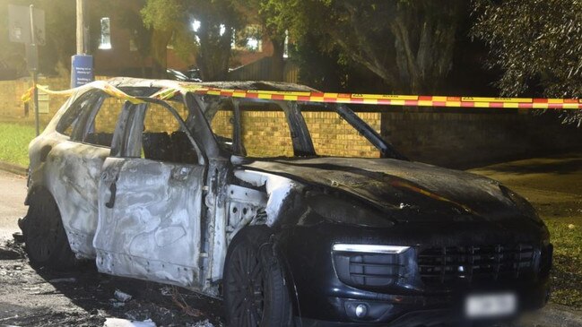 A white Porsche pictured in the street covered in black ash. Picture: NSW Police