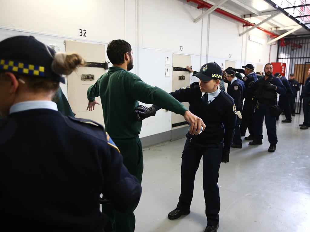 Correctional officer trainee Rhiannan Harvey searches a Long Bay prisoner. Picture: Tim Hunter