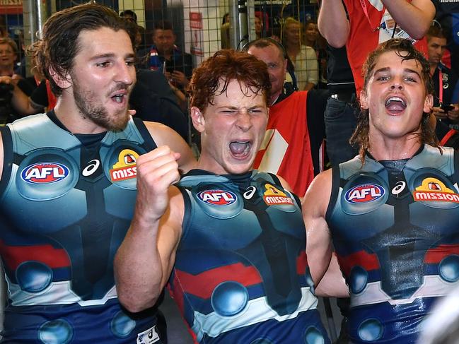 MELBOURNE, AUSTRALIA - MARCH 23: Marcus Bontempelli, Ed Richards and Bailey Smith of the Bulldogs sing the song in the rooms after winning the round one AFL match between the Western Bulldogs and the Sydney Swans at Marvel Stadium on March 23, 2019 in Melbourne, Australia. (Photo by Quinn Rooney/Getty Images)