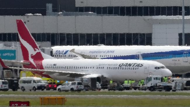 The Qantas Boeing 737 surrounded by emergency vehicles after issuing a mayday call following an engine failure, en route from Auckland to Sydney on January 18. Picture: Andrew Leeson/AFP