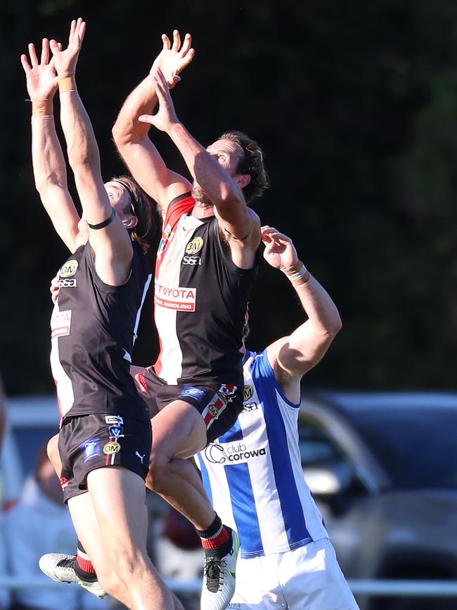 Myrtleford defenders Zac Pethybridge and Simon Curtis fly for the ball.