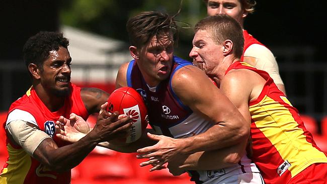 Jarrod Garlett (left) of the Gold Coast Suns reserve team challenges Josh Clayton (centre) of Brisbane Lions during the match at the Metricon stadium, Gold Coast. Photo: Regi Varghese