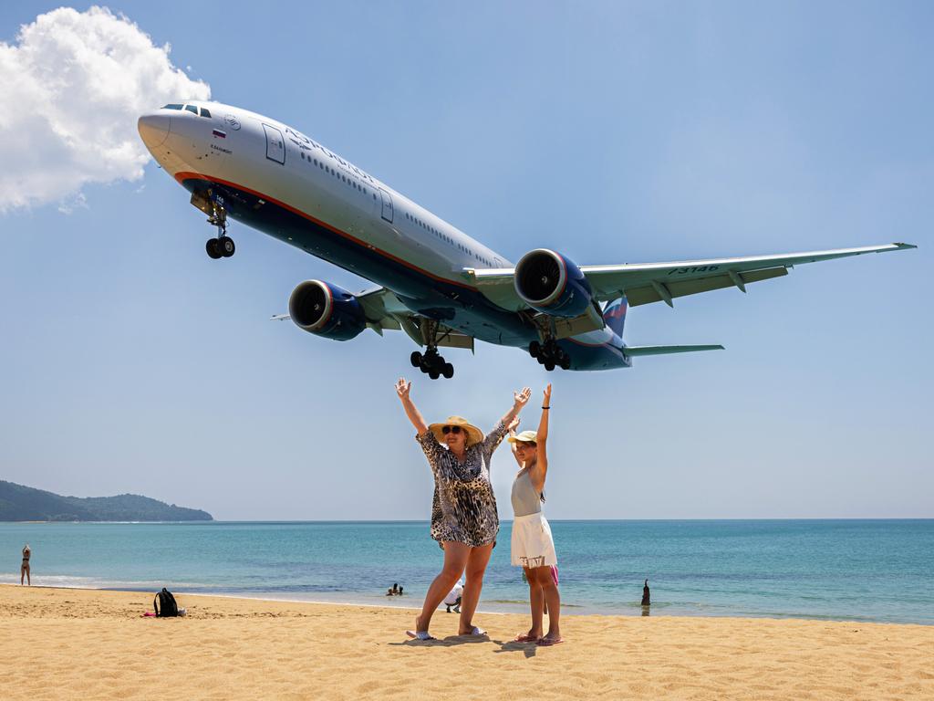 Russian tourists snap photos with landing planes on Phuket’s Mai Khao Beach, as the upcoming season of “The White Lotus” boosts Thailand’s international tourism. Picture: Lauren DeCicca/Getty Images