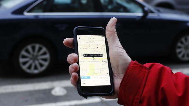 An UBER application is shown as cars drive by in Washington, DC on March 25, 2015. Uber said it was ramping up safety in response to rape allegations against a driver in India and growing concerns about background checks for operators of the popular ride-sharing service. In other cities where Uber operates, critics had complained that a lack of licensing and background checks of drivers could imperil those who use the service. AFP PHOTO/ ANDREW CABALLERO-REYNOLDS